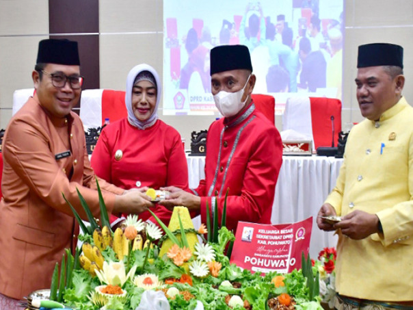 Pj. Gubernur saat menerima potongan tumpeng dari Bupati Pohuwato. Foto Iwan Karim